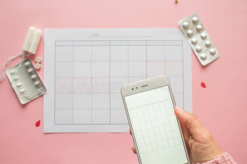 Menstrual cycle. Calendar for the month with marks and a mobile application on the smartphone screen. royalty free stock images