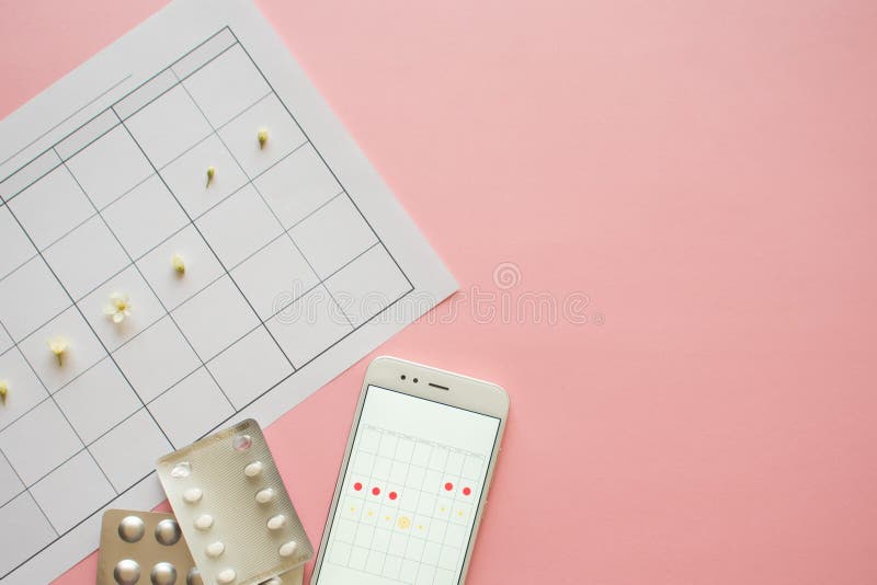 Menstrual cycle. Calendar for the month with marks and a mobile application on the smartphone screen. stock photos