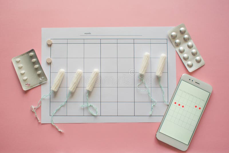Menstrual cycle. Calendar for the month with marks and a mobile application on the smartphone screen. royalty free stock image