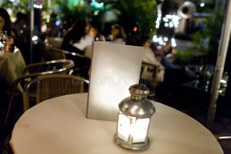 Blank menu on empty table at outdoor restaurant at nightime. Blank menu on empty table at outdoor restaurant at nightime