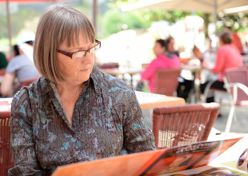 Mulher a ler o menu do café fotografia de stock royalty free
