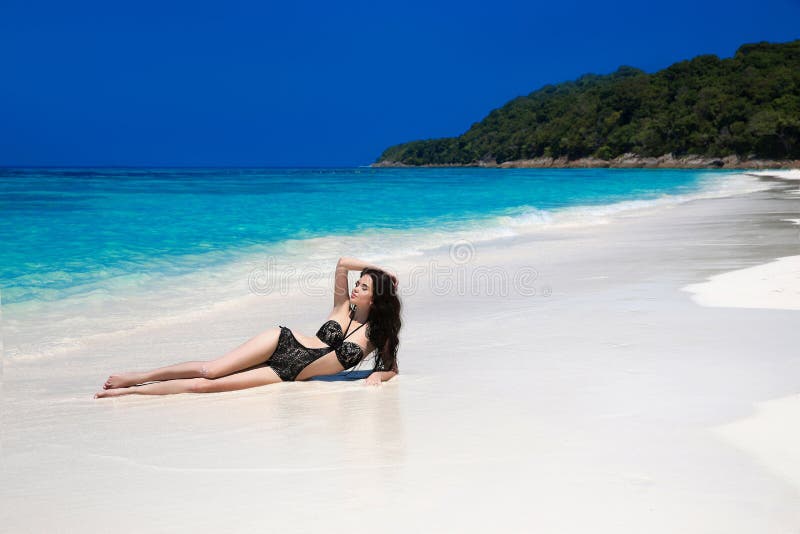 Menzogne di modello del bello bikini sexy sulla spiaggia tropicale Por all'aperto immagini stock libere da diritti