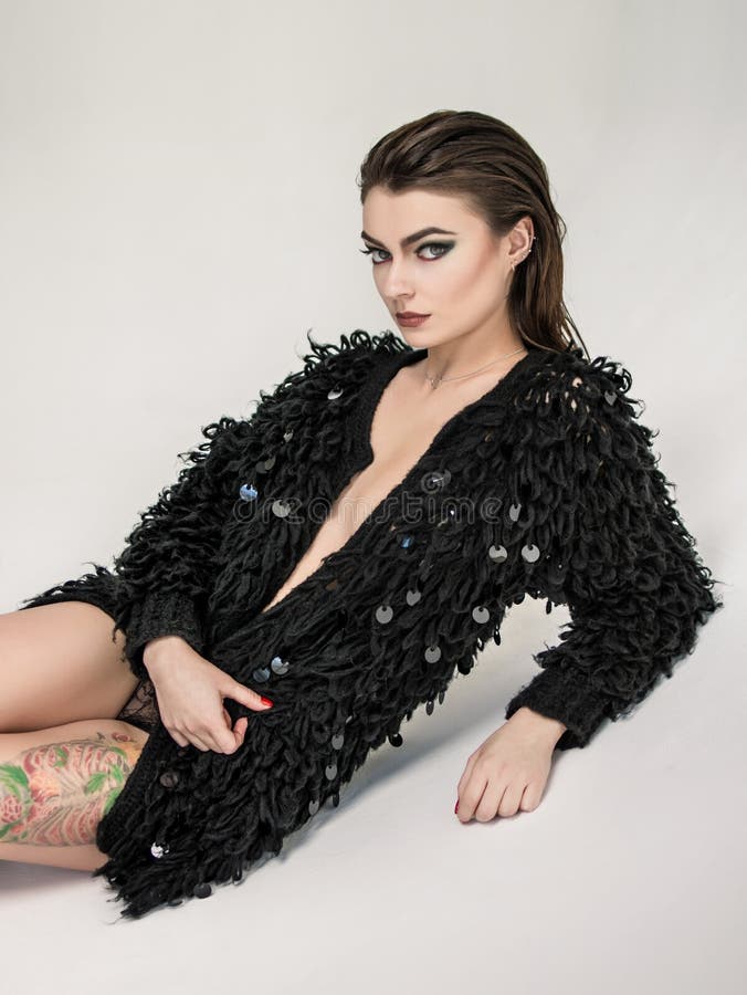 Menzogne di modello della donna in rivestimento nero fotografia stock libera da diritti