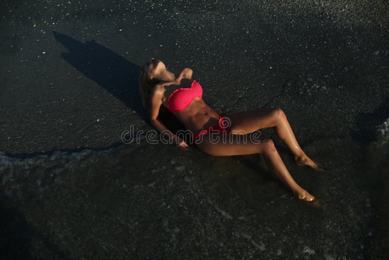 Menzogne di modello femminile sulla spiaggia fotografie stock