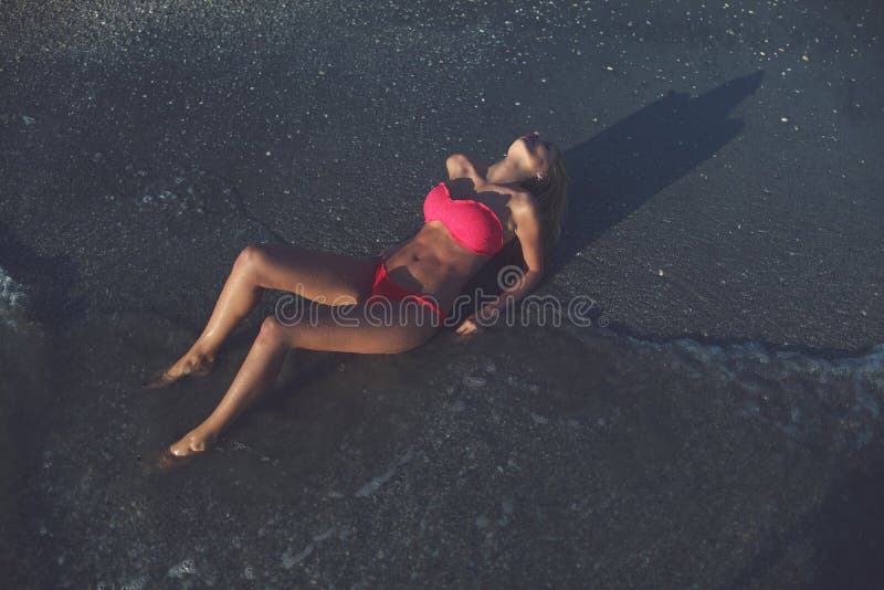 Menzogne di modello femminile sulla spiaggia immagini stock libere da diritti