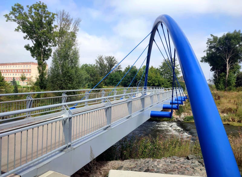 In the scope of the city redevelopment for the BUGA2021, this roughly 24-ton arch bridge - nicknamed the `Blue Wonder of Gispersleben` - with an approximate radius of 25 meters and 7.5 meters in height was installed to replace an older footbridge in newly created Kilianipark in the north of Erfurt. Thuringia, Germany September 4th, 2021. In the scope of the city redevelopment for the BUGA2021, this roughly 24-ton arch bridge - nicknamed the `Blue Wonder of Gispersleben` - with an approximate radius of 25 meters and 7.5 meters in height was installed to replace an older footbridge in newly created Kilianipark in the north of Erfurt. Thuringia, Germany September 4th, 2021