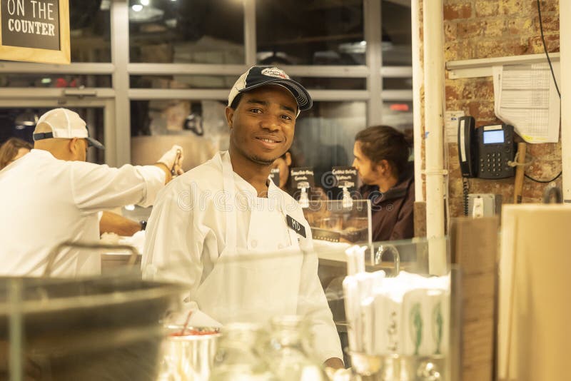 MERCADO DE CHELSEA, NEW YORK CITY, LOS E.E.U.U. - 14 DE MAYO DE 2018: Personal de Chelsea Market durante el tiempo de trabajo imagenes de archivo MERCADO DE CHELSEA, NEW YORK CITY, LOS E.E.U.U. - 14 DE MAYO DE 2018: Personal de Chelsea Market durante el tiempo de trabajo imagenes de archivo