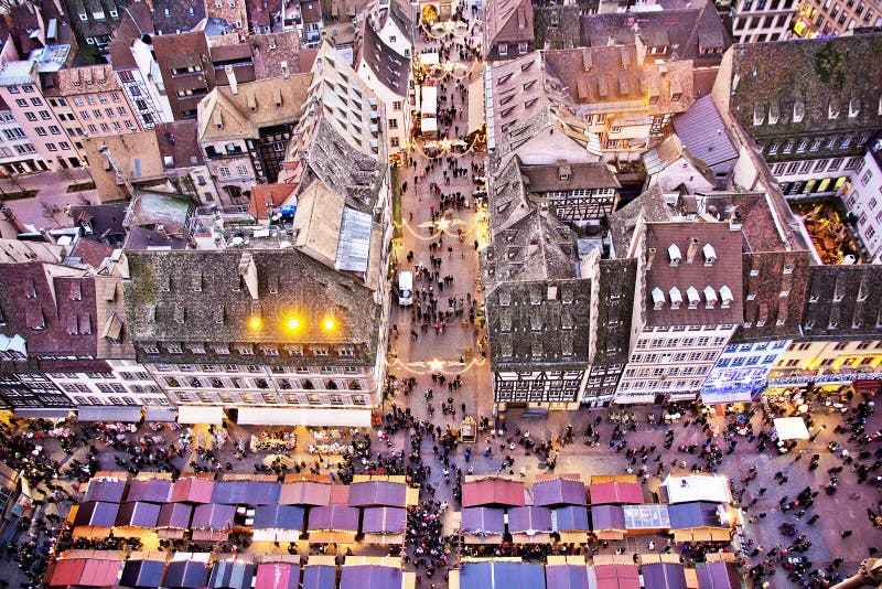 View of the crowded golden Christmas Market stalls from the top of the Cathedral of Strasbourg at the sunset and golden hour moment, France. View of the crowded golden Christmas Market stalls from the top of the Cathedral of Strasbourg at the sunset and golden hour moment, France