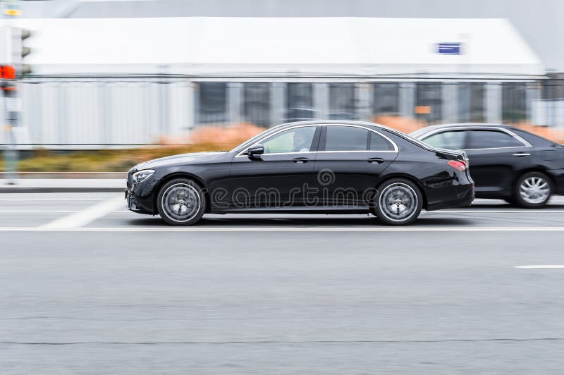 Moscow, Russia - October 2021: Mercedes-Benz E-Class W213 Facelift riding the streets. Panning shot of black shiny car running on the city road. Moscow, Russia - October 2021: Mercedes-Benz E-Class W213 Facelift riding the streets. Panning shot of black shiny car running on the city road