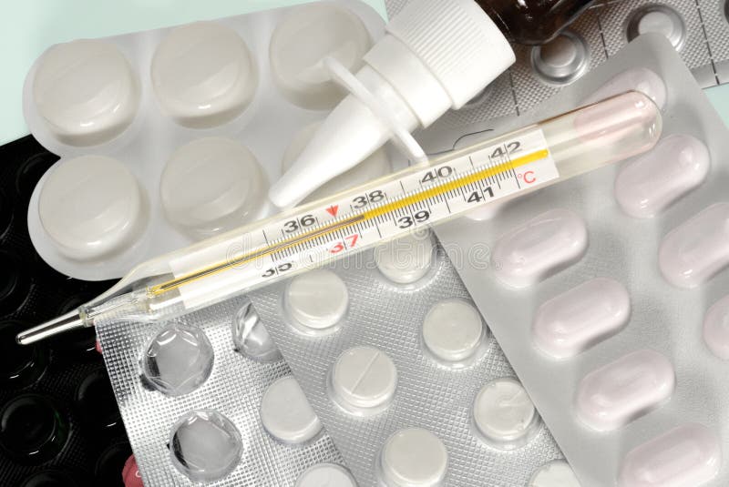 Mercury termometer, nasal sprej och blåsor med piller F?rkylning- och influensabehandlingbegrepp N?ra ?vre makro arkivbild Mercury termometer, nasal sprej och blåsor med piller F?rkylning- och influensabehandlingbegrepp N?ra ?vre makro arkivbild