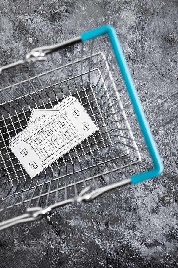 Merging and holdings, bank made of paper inside of shopping basket ready to be bought by a competitor royalty free stock photography Merging and holdings, bank made of paper inside of shopping basket ready to be bought by a competitor royalty free stock photography