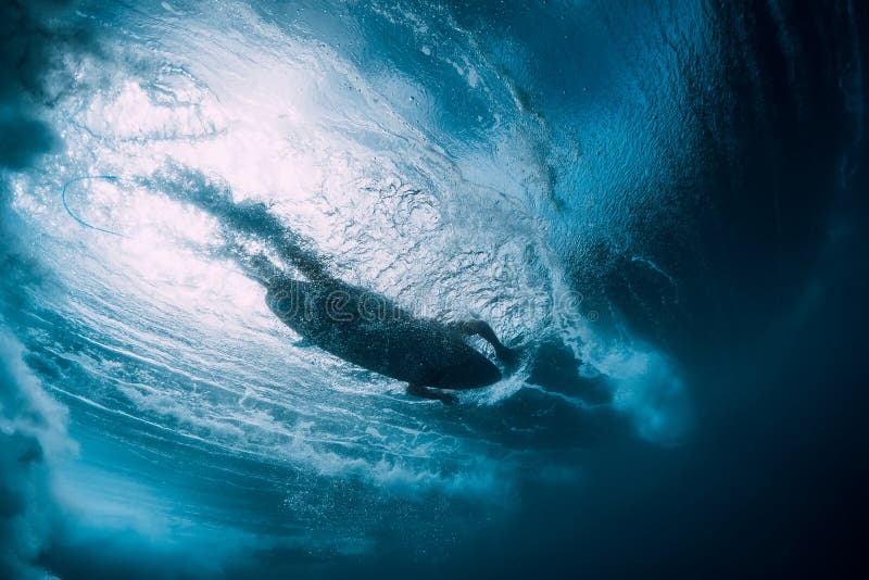 Surfer at surfboard swim in blue ocean, underwater view. Surfer at surfboard swim in blue ocean, underwater view