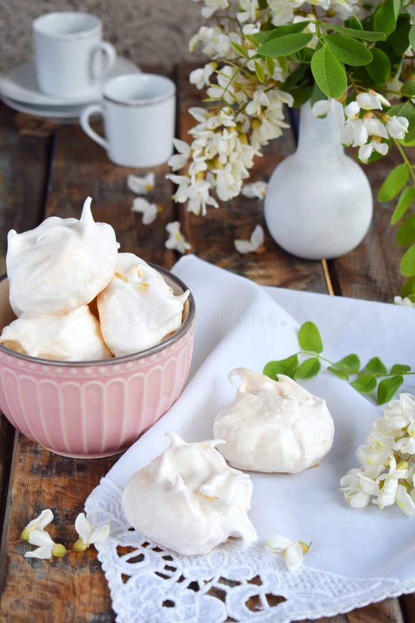 Meringues cookies and cup of coffee. Homemade Meringue kisses drops with acacia flowers. Vintage photo. Copy space stock photo Meringues cookies and cup of coffee. Homemade Meringue kisses drops with acacia flowers. Vintage photo. Copy space stock photo