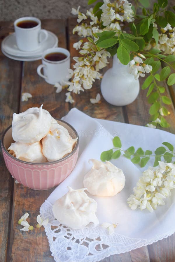 Meringues cookies and cup of coffee. Homemade Meringue kisses drops with acacia flowers. Vintage photo. Copy space royalty free stock photos Meringues cookies and cup of coffee. Homemade Meringue kisses drops with acacia flowers. Vintage photo. Copy space royalty free stock photos