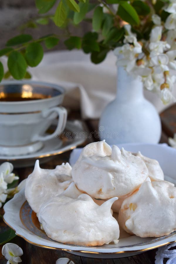 Meringues cookies and cup of coffee. Homemade Meringue kisses drops with acacia flowers. Vintage photo. Copy space stock photography Meringues cookies and cup of coffee. Homemade Meringue kisses drops with acacia flowers. Vintage photo. Copy space stock photography