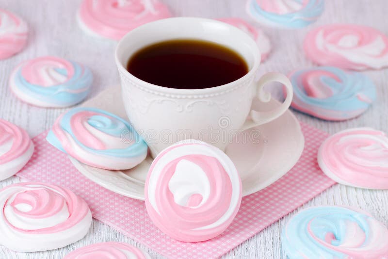 Meringues in pastel colors with a cup of coffee and a pink serviette royalty free stock photo Meringues in pastel colors with a cup of coffee and a pink serviette royalty free stock photo