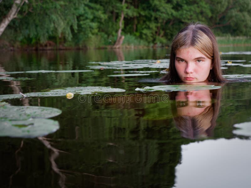 Mermaid Girl in the Water among Water Lilies at Sunset Stock Photo ...