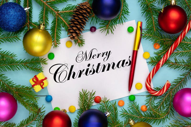 Merry Christmas background, green fir branches, red and blue, pink, yellow, ball, candies, cone, gift box, white sheet and a pen
