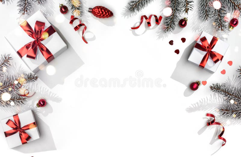 Merry Christmas card made of fir branches, gift boxes, red decoration, sparkles and confetti on white background. Xmas and New