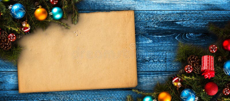 Merry Christmas Frame with real wood green pine, colorful baubles, gift boxe and other seasonal stuff over an old wooden aged back