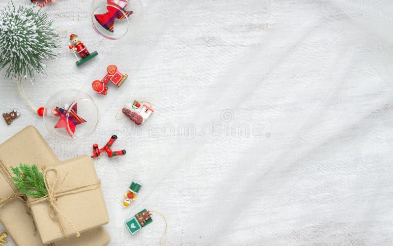 Merry Christmas and Happy New Year background with xmas decorations and gift boxes on nest fabric on white wooden board stock photography Merry Christmas and Happy New Year background with xmas decorations and gift boxes on nest fabric on white wooden board stock photography