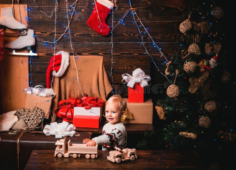 Merry Christmas and Happy New year. Cute little child girl is decorating the Christmas tree indoors. Christmas Gift royalty free stock image