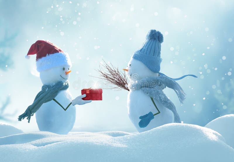 Two cheerful snowmen standing in winter christmas landscape.