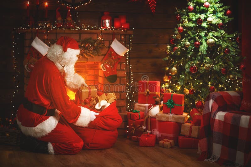 Merry Christmas! santa claus near the fireplace and tree with gi