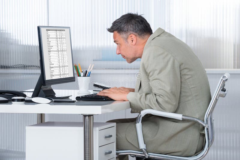 Mesa concentrada de Using Computer At do homem de negócios