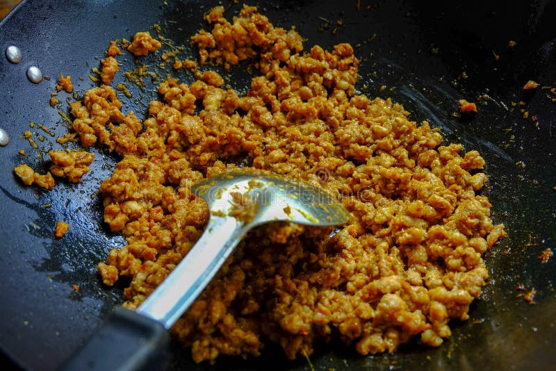 Stir fried curry paste with meat in pan use ladle to stir. Stir fried curry paste with meat in pan use ladle to stir