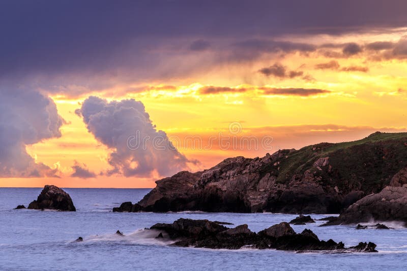 Mesmerizing scenery of a cliff in a sea during sunset royalty free stock images