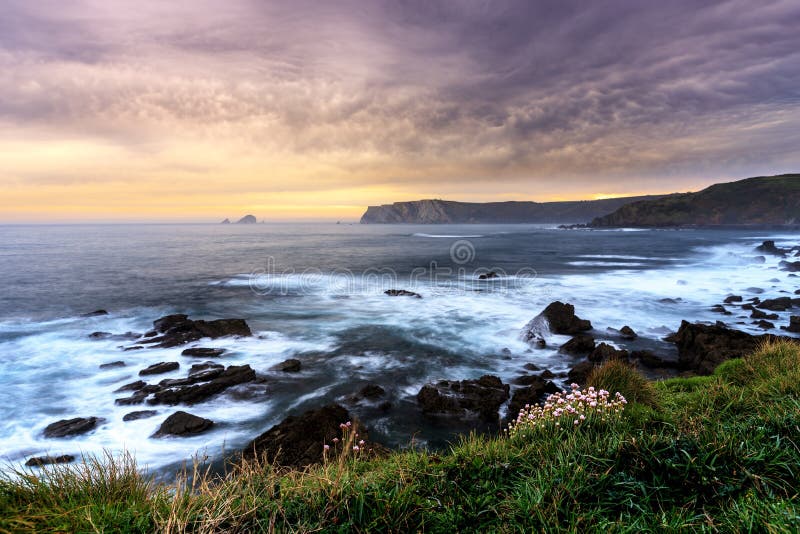 Mesmerizing scenery of a sea with hills in the horizon during twilight-perfect wallpaper royalty free stock photo
