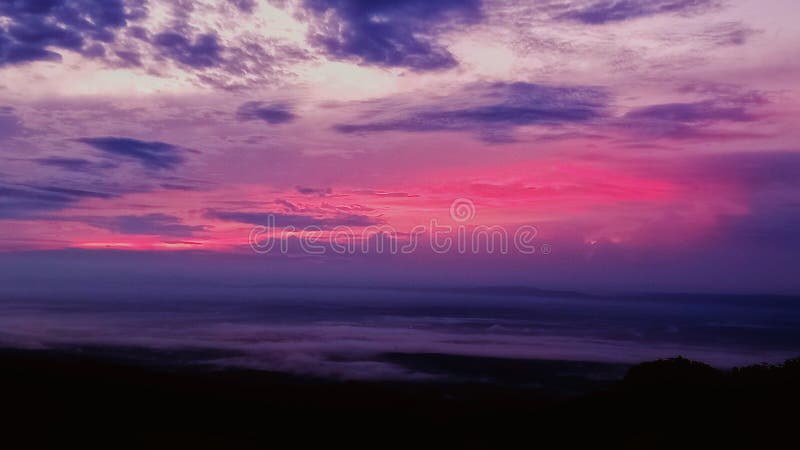 ?A mesmerizing view of a colorful sunrise over a sea of clouds . sunrise cloudscape colorfulsky stock image