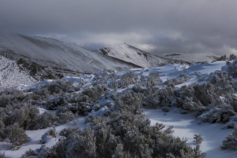 Mesmerizing view of the fields and hills covered in snow on a cloudy day stock photo