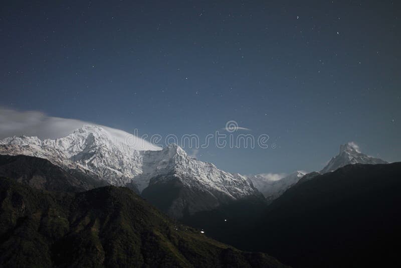 Mesmerizing view of the mountains covered in snow under the starry night stock image