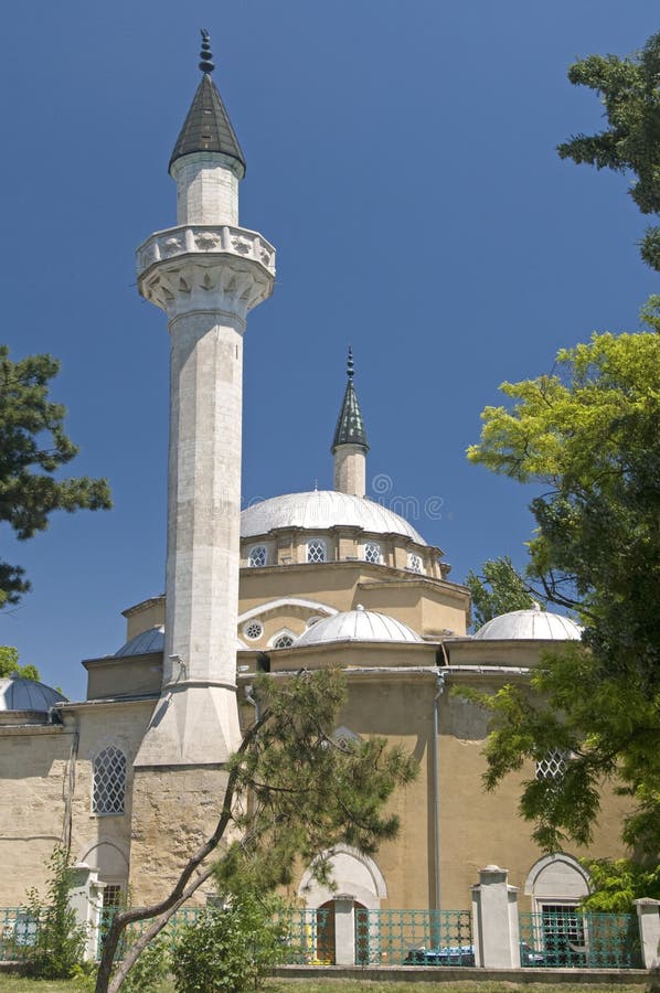 The Juma-Jami Mosque designed in 1522 by Mimar Sinan is situated in Yevpatoria (Eupatoria), Crimea. The Mosque is situated against the blue sky background and rounded with green trees. The Juma-Jami Mosque designed in 1522 by Mimar Sinan is situated in Yevpatoria (Eupatoria), Crimea. The Mosque is situated against the blue sky background and rounded with green trees.