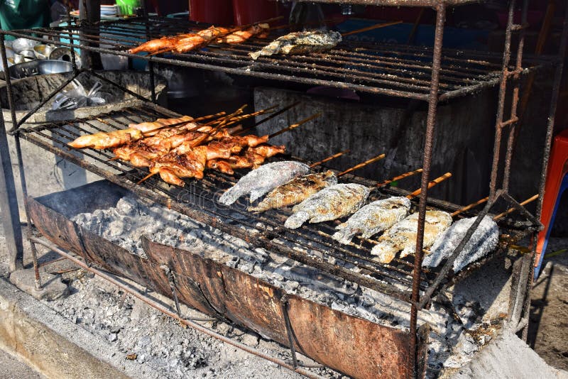 Messa a fuoco morbida sul pollo grigliato e sul pesce grigliato o sul sale di pesce grigliato, sulla griglia o sul forno di carbo immagini stock Messa a fuoco morbida sul pollo grigliato e sul pesce grigliato o sul sale di pesce grigliato, sulla griglia o sul forno di carbo immagini stock
