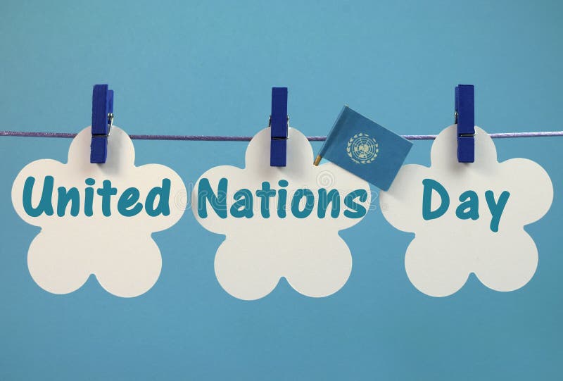 Message de salutation de jour de Nations Unies écrit à travers les étiquettes blanches avec le drapeau pendant des chevilles bleue