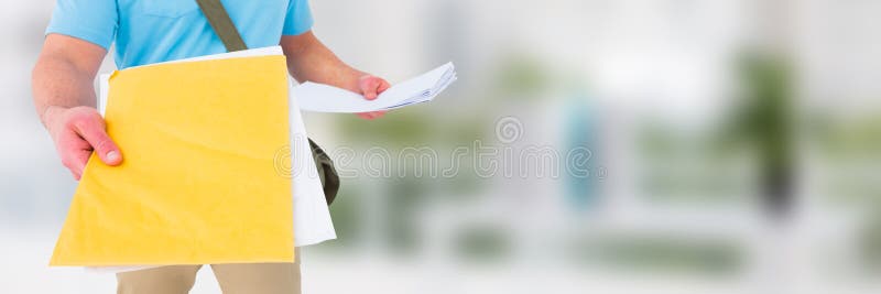 Messager de la livraison tenant des formes devant le fond brouillé image stock Messager de la livraison tenant des formes devant le fond brouillé image stock