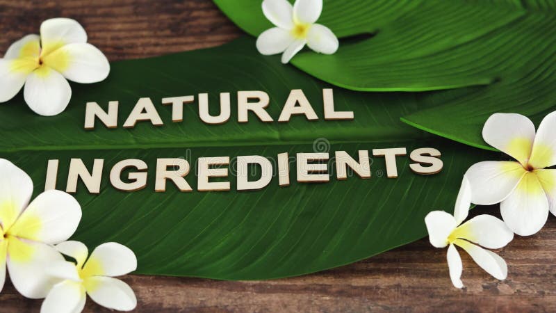 Messaggio 'Ingredienti naturali' sulla foglia di banana tropicale con fiori di monoi frangipani con una telecamera panoramica ori