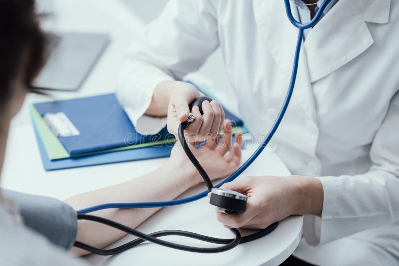 Messender Blutdruck des Doktors lizenzfreies stockfoto Messender Blutdruck des Doktors lizenzfreies stockfoto