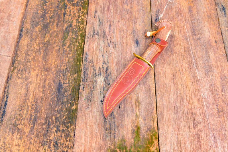 Messer für das Wandern im Hüllenbraunleder auf hölzernem Weinlesehintergrund mit Kopienraum addieren Text stockbild Messer für das Wandern im Hüllenbraunleder auf hölzernem Weinlesehintergrund mit Kopienraum addieren Text stockbild