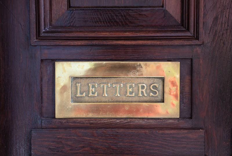 MessingpostBriefkasten auf einer hölzernen Haustür, Textbuchstaben. Bronzebriefkasten Messingbriefkastenplatte auf einer hölzernen Haustür, Textbuchstaben Nahaufnahmeansicht mit Details