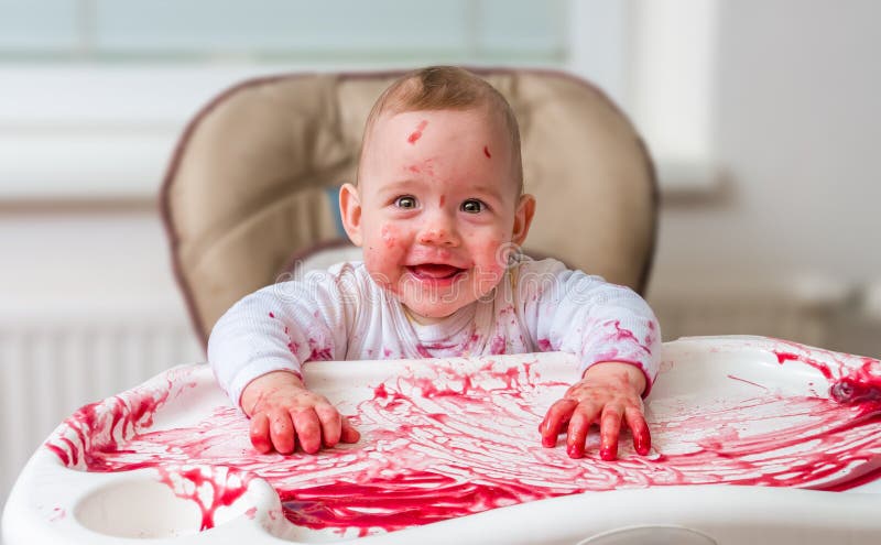 Messy and dirty baby is eating snack with hands royalty free stock photos.