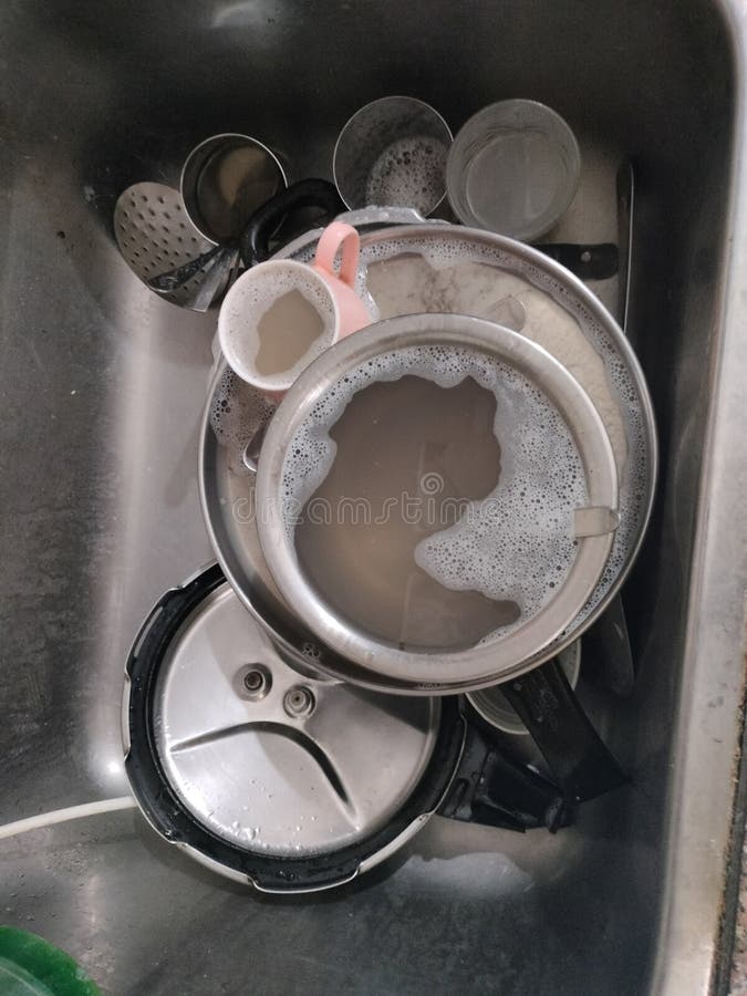 Messy Kitchen Sink with Used Utensils stock photo