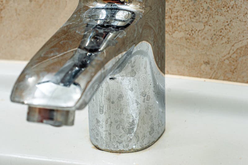 Messy Tap Leg in Stains from Hard Water on a White Ceramic Sink Stock
