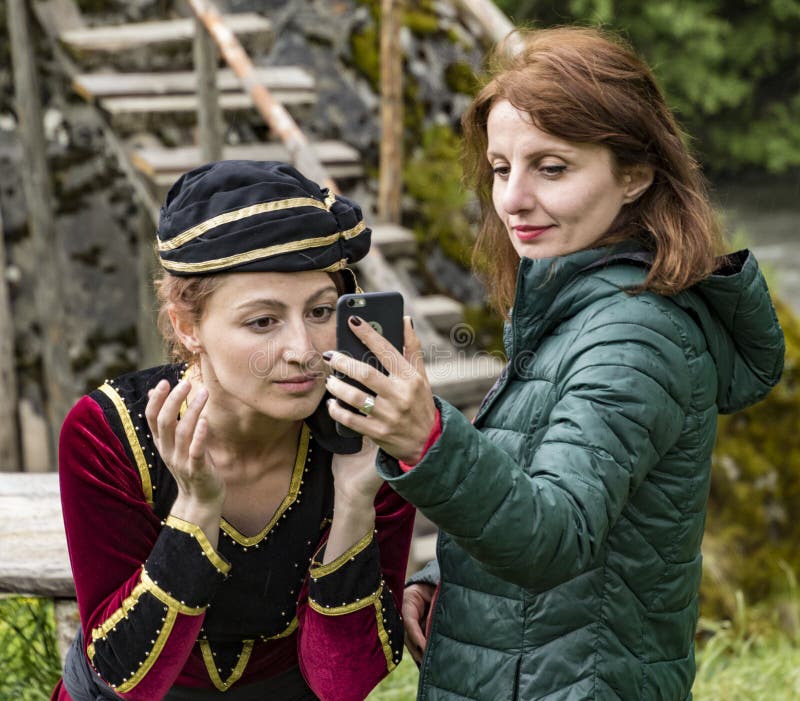 Mestia, Georgia - 11 juni 2016 - Female-modellen fixerar hennes smink med hjälp av en mobiltelefonkamera royaltyfria foton Mestia, Georgia - 11 juni 2016 - Female-modellen fixerar hennes smink med hjälp av en mobiltelefonkamera royaltyfria foton