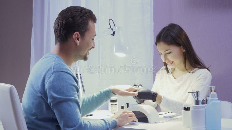 Mestre e cliente no salão de beleza do tratamento de mãos