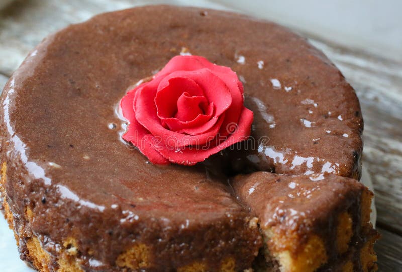 Met de hand gemaakt biscuitgebak met chocolade het berijpen Kleine cake met cacao ganache glans De rode suiker nam verfraaid toe stock foto Met de hand gemaakt biscuitgebak met chocolade het berijpen Kleine cake met cacao ganache glans De rode suiker nam verfraaid toe stock foto