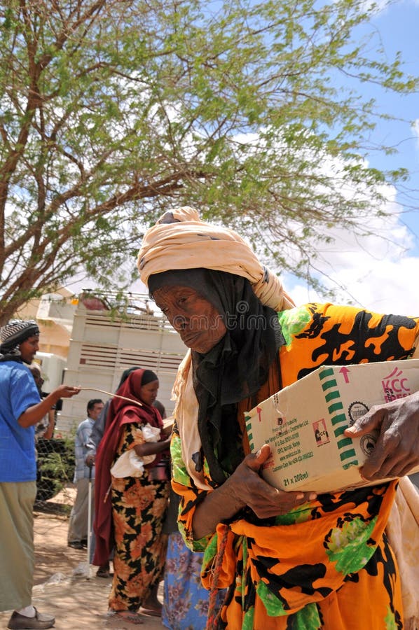 Met de hulp Afrikanen na oude vrouwennaar huis terug:keren stock fotografie Met de hulp Afrikanen na oude vrouwennaar huis terug:keren stock fotografie